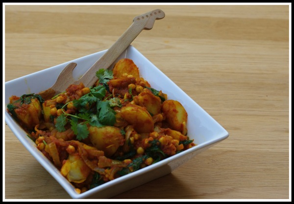 A bowl of the Chick pea salad with a wooden guitar spoon 