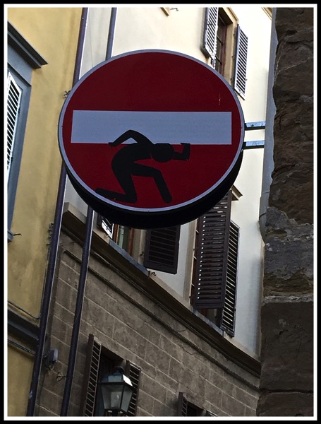 A figure looking like he's carrying the horizontal block of a no entry sign