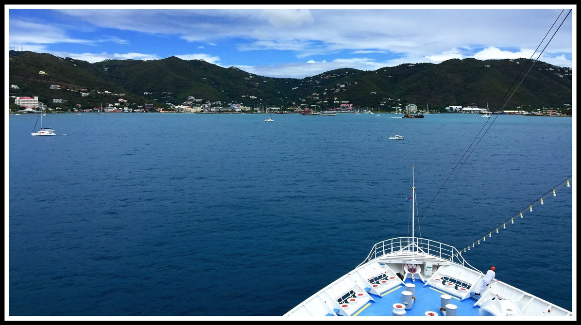 A view of the front tip of the boat in front of a beautiful landscape
