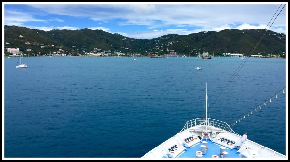 A view of the front tip of the boat in front of a beautiful landscape