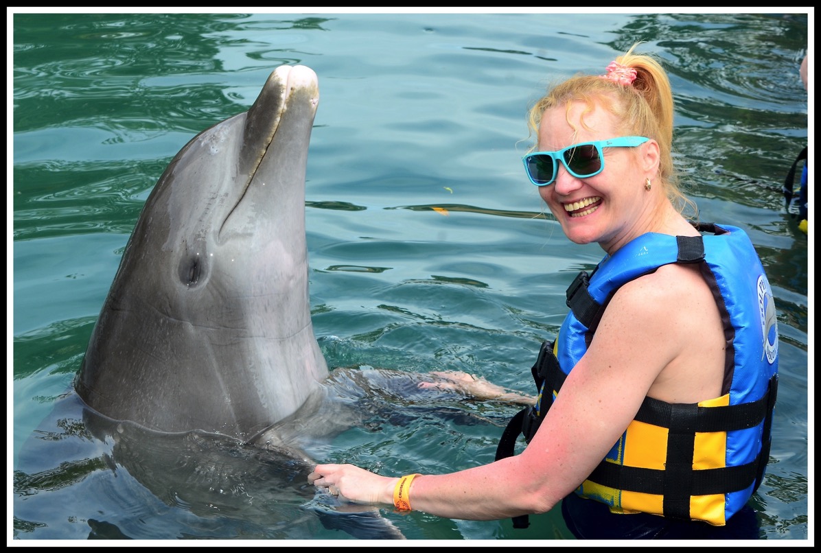 Sarah stood on the right holding both flippers whilst having a dance with the dolphin