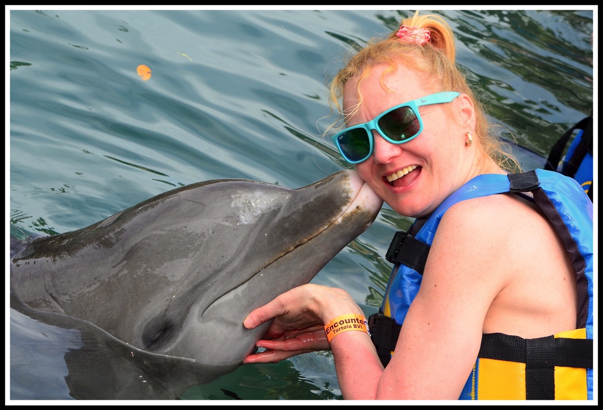 Sarah getting a kiss from the dolphin
