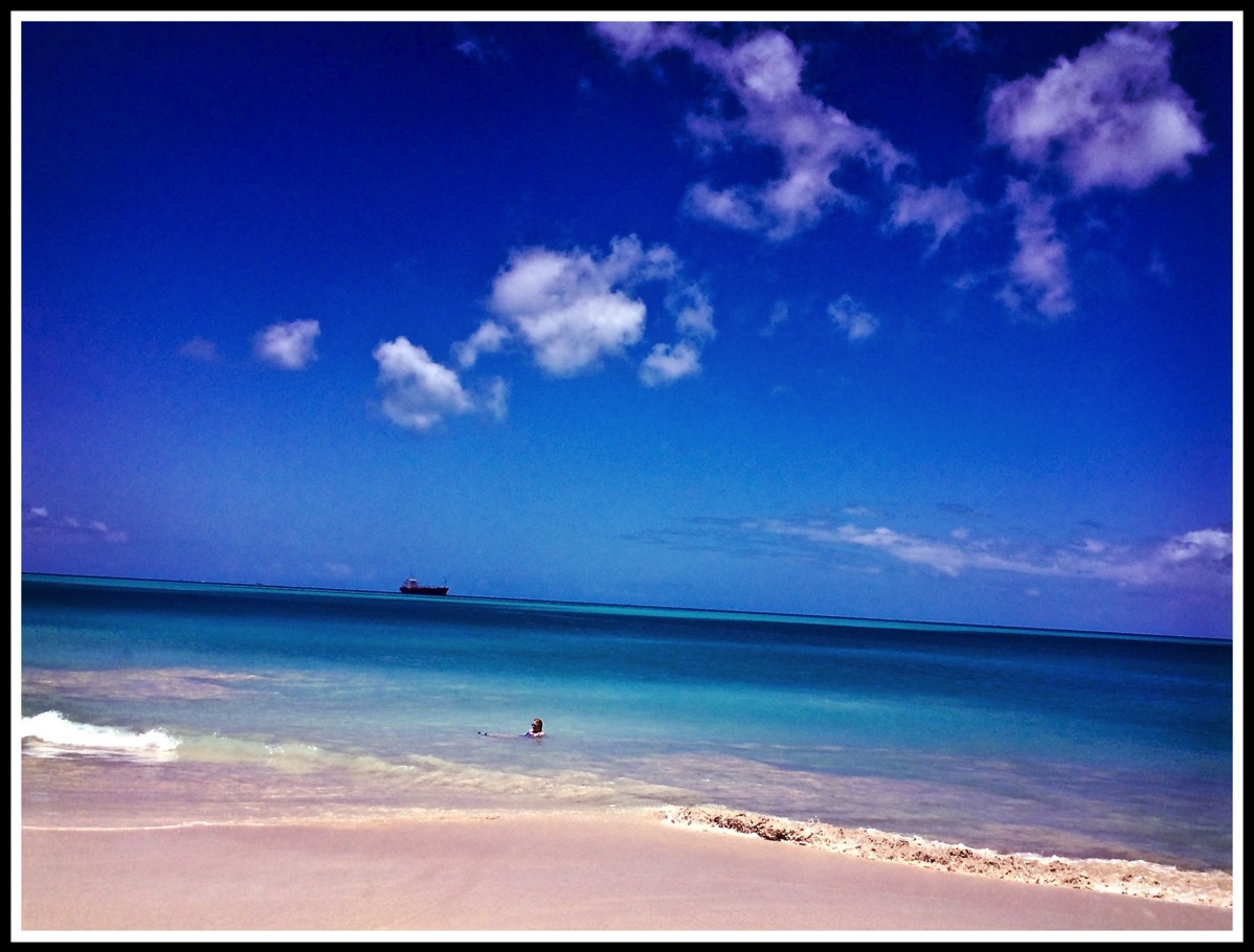 Sarah submerged in the turquoise sea. The whole sea is empty apart from Sarah
