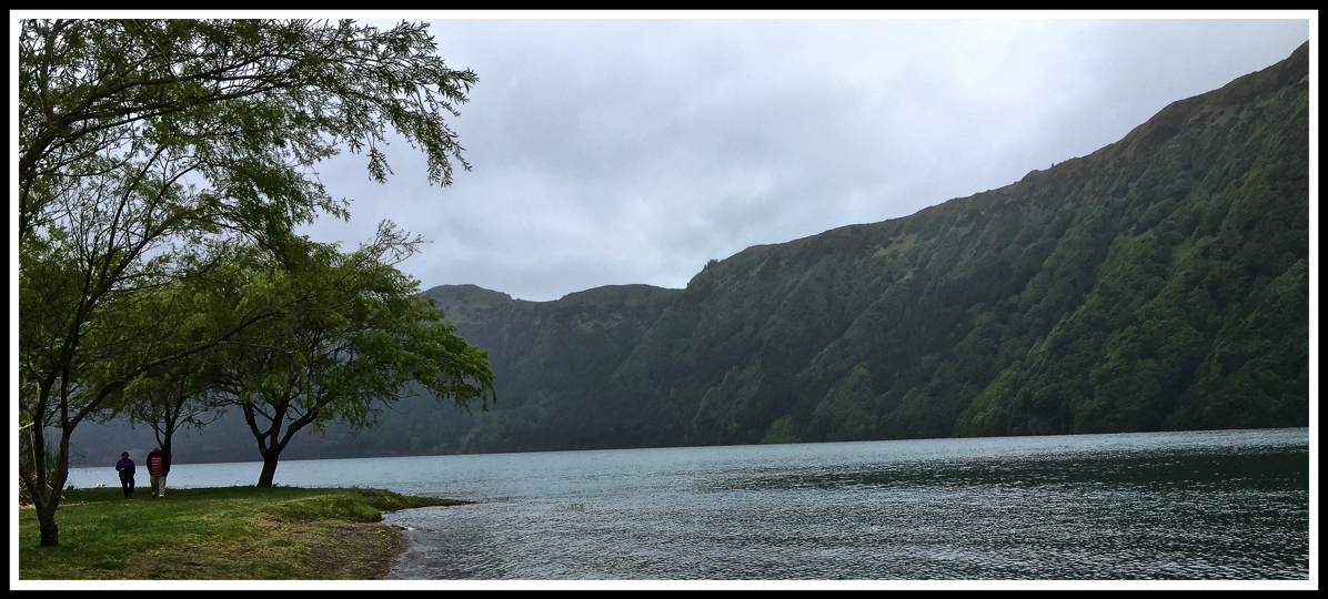 View of Sao Miguel river from a grass bank with volcanic rocks behind
