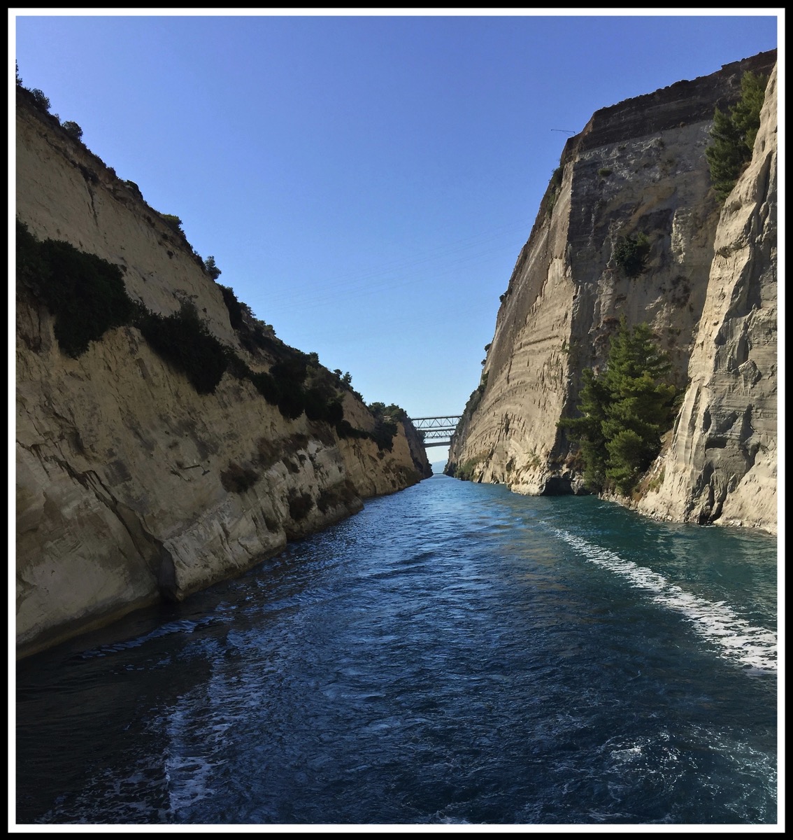 photo taken from the rear of the boat with the beautiful blue water with hight walls either side