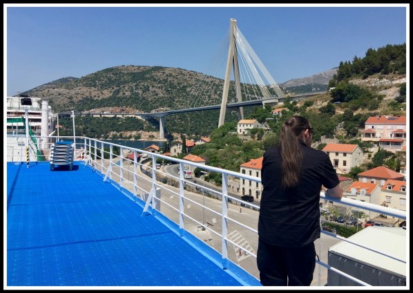 Me lent against the railing looking out across the landscape and bridge of Dubrovnik