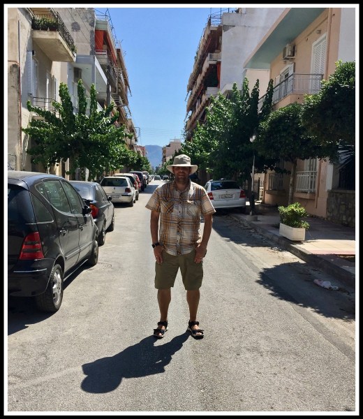 Me stood in the middle of the road with buildings either side in Corinth