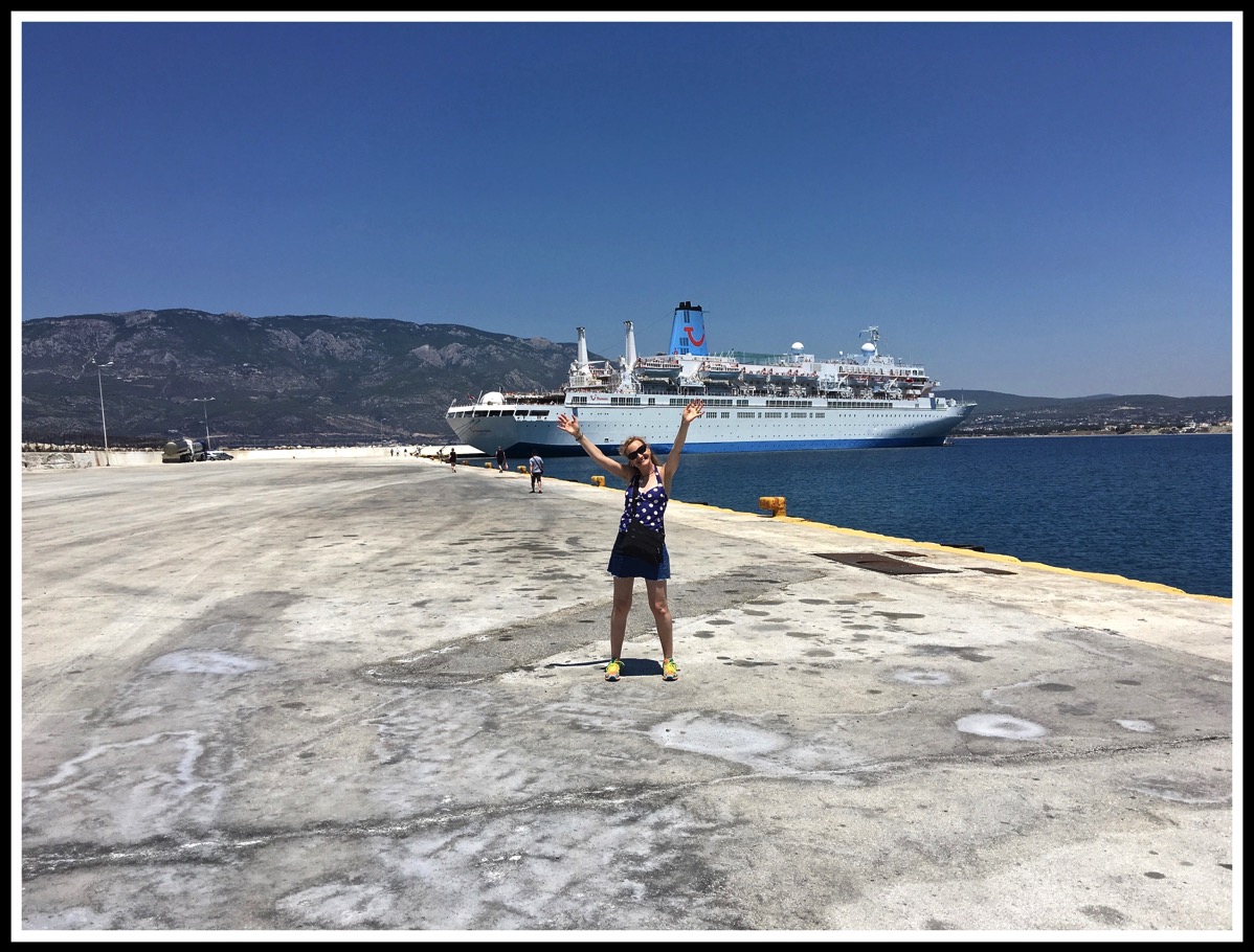 Sarah stood in front of the Thomson Spirit shipwith both arms in the air