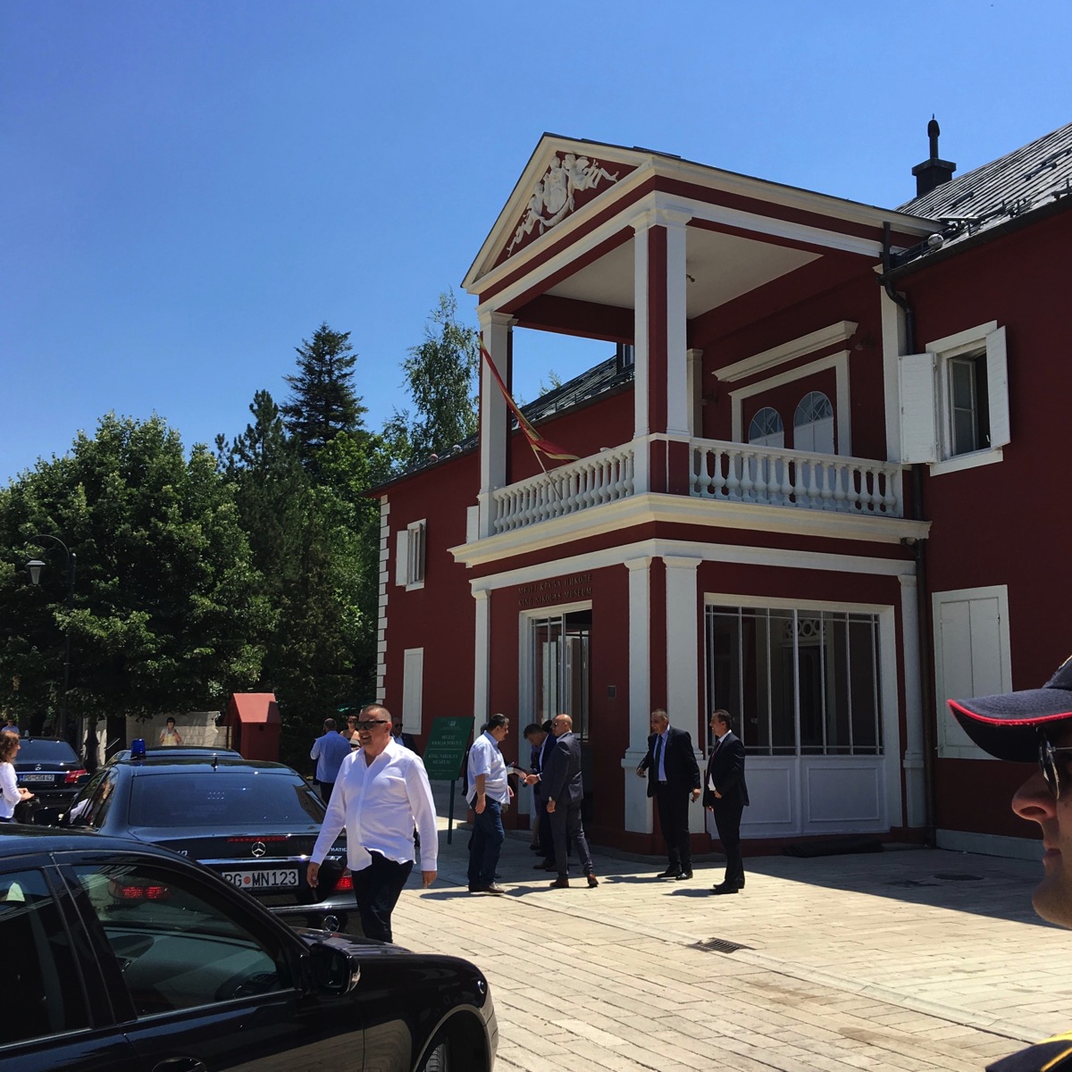 a little further away from the rear black car and looking round to the right at the president 