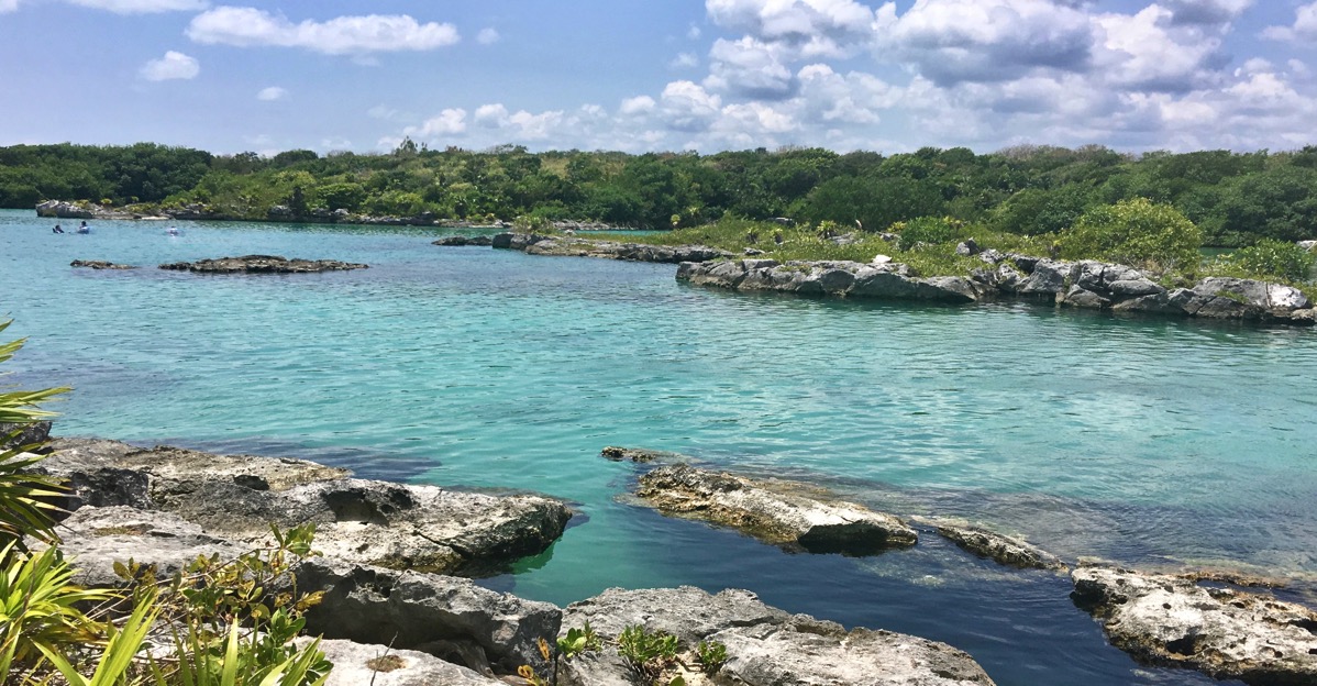 a panorama taken on one side of the river and looking over to the other side. The river running left to right