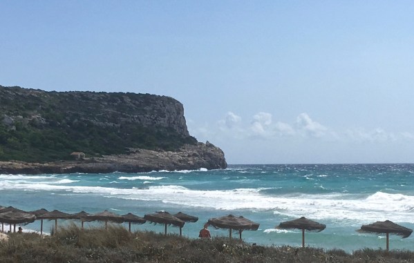 view of rolling hiss joining the sea with the beach in the front