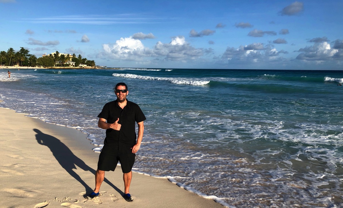 Me stood on the beach with my thumb up in Barbados