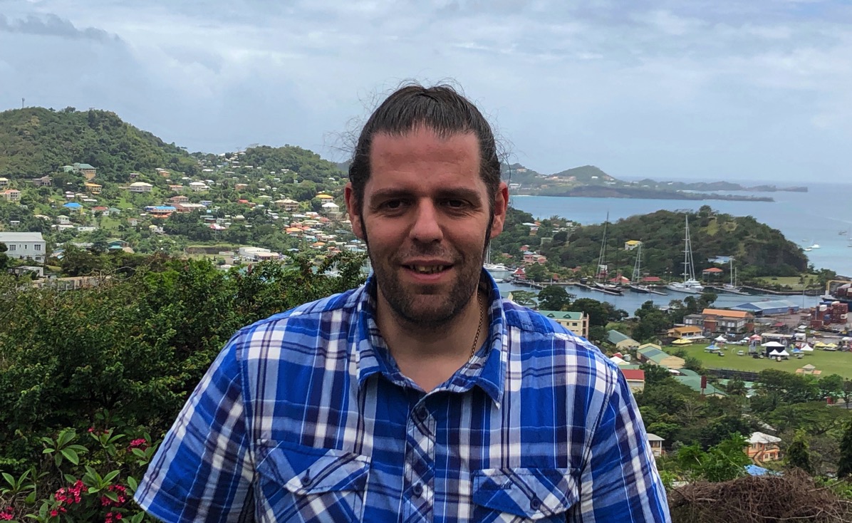 me in my blue chequed shirt in front of the green landscape and rolling hills