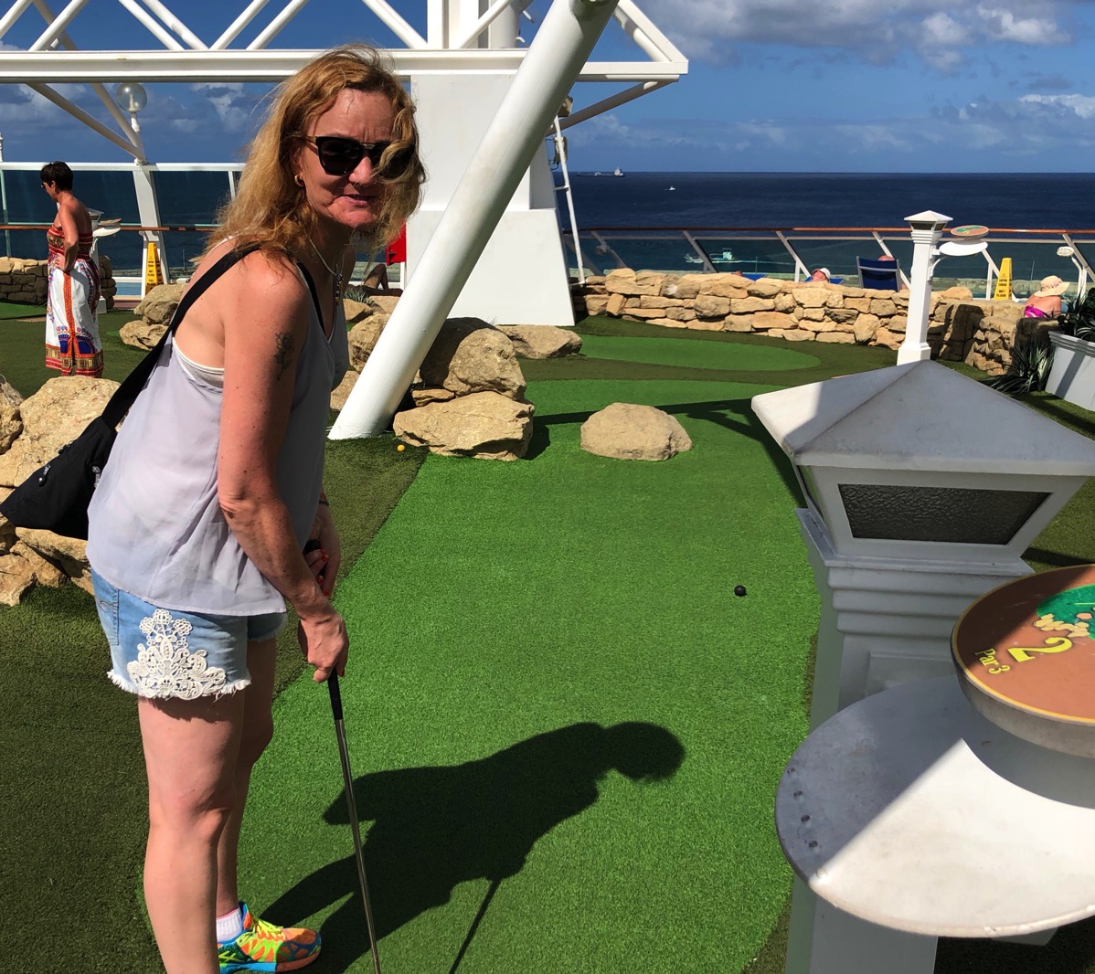Sarah playing crazy golf on the top deck of the ship