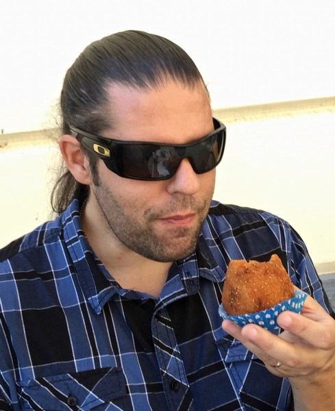 Me sat outside eating a Arancini wearing my sunglasses