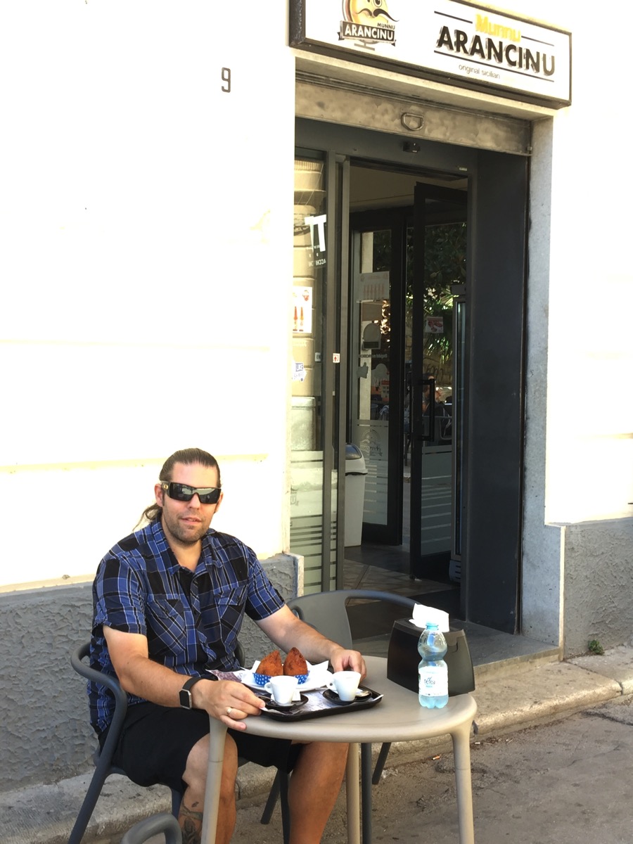 me sat outside the Arancinu place with the arancini on a plate with a coffee