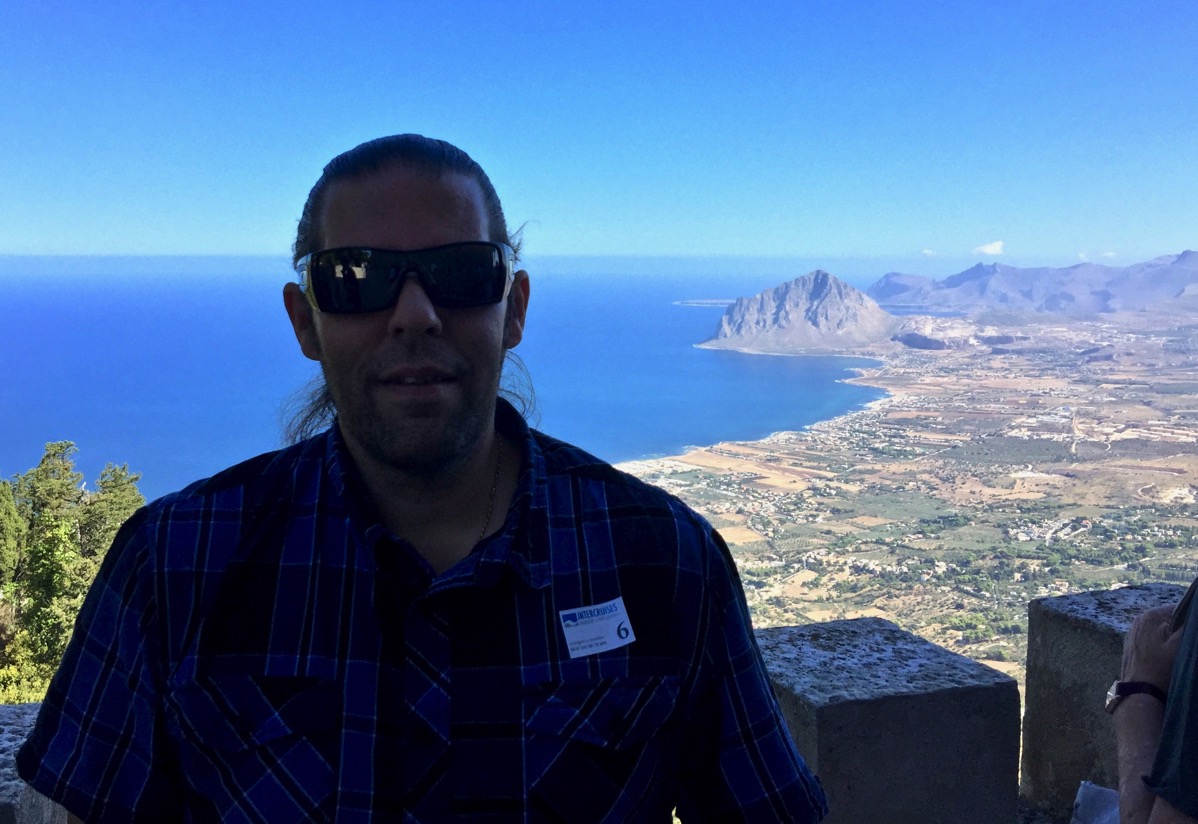 Me smiling at the camera sat in the cable car view from the cabe car looking down the rolling hills down to the sea