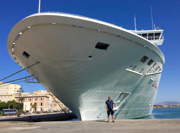 ME STOOD UNDERNEATH THE FRONT OF THE SHIP THAT LOOKS HUGE AND IS TOWERING OVER ME
