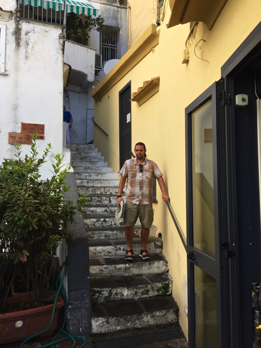 Me walking down some stairs in a built up town 