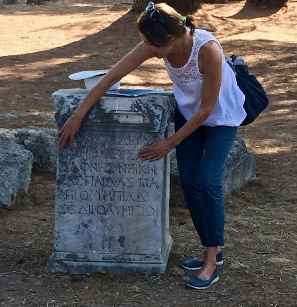 Our tour guide reading some ancient greek carved in a stone on the floor