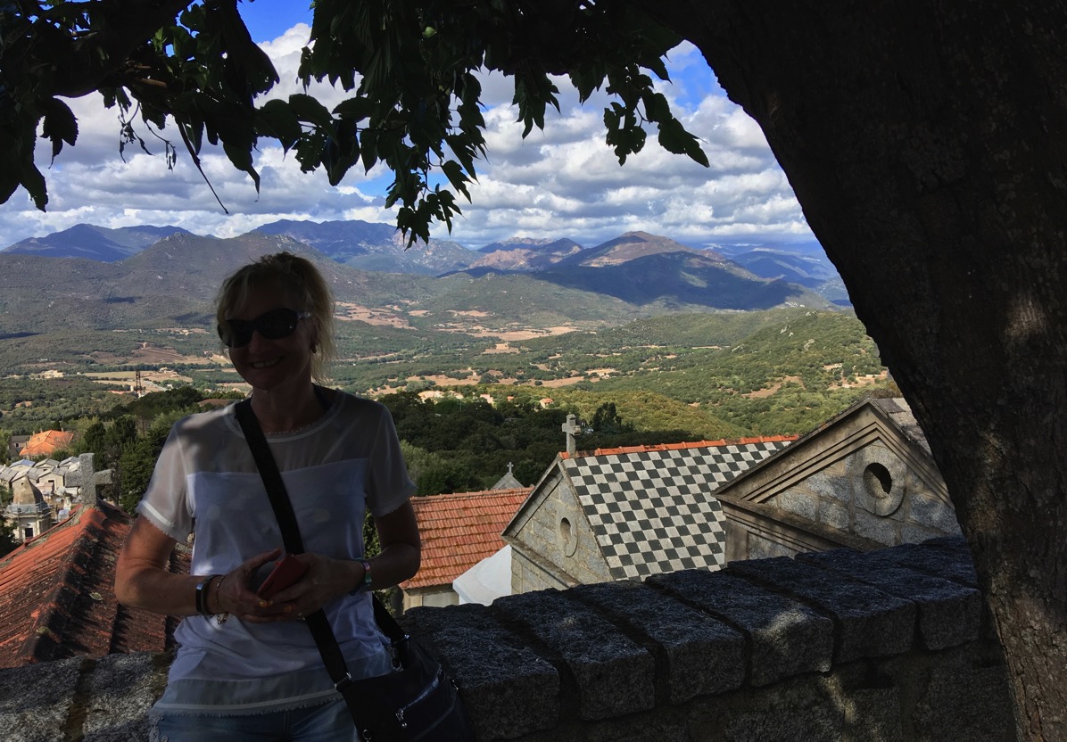 Photo of Sarah under a tree with the Corsica hills in the background