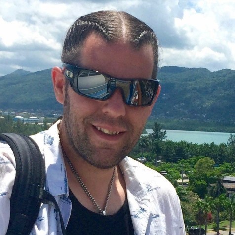 Portait of my smiling at the camera with shades on and braided har