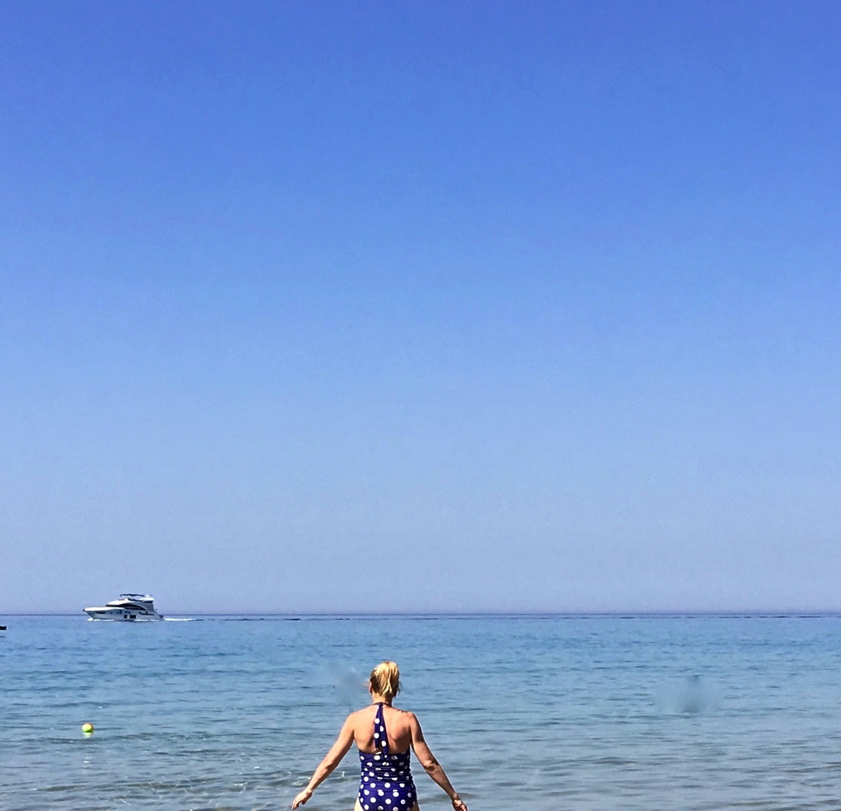 Sara at the very bottom walking out to sea with the huge seascape in front of her