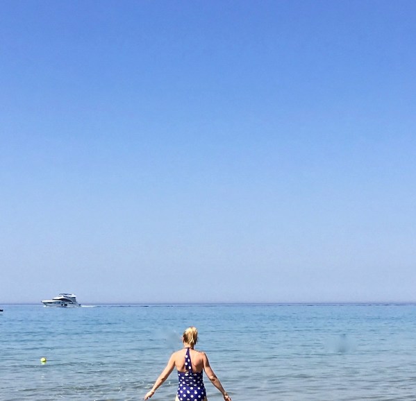 Sara at the very bottom walking out to sea with the huge seascape in front of her