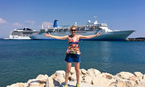 Sarah doing a i have conquored pose on the dock with the ship in the background