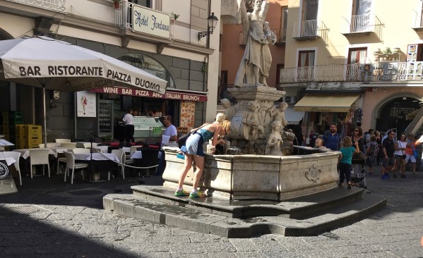 Sarah drinking from the natural water fountain in the Amalfi square