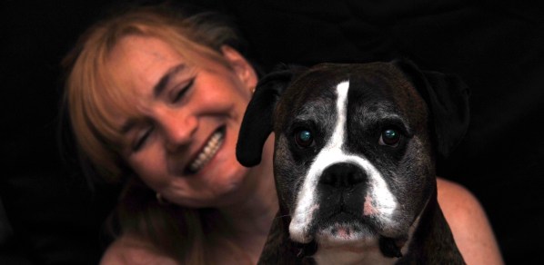 Sarah laughing behind Bruc who doesn't look amused