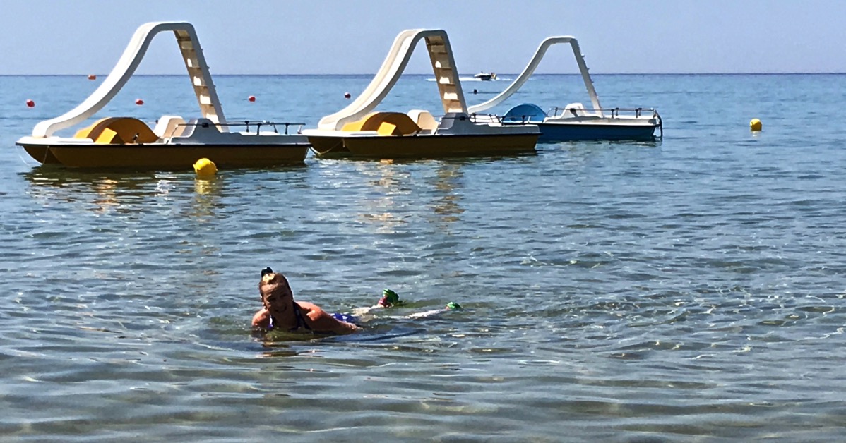 Sarah lay down in the sea with a pier in the background