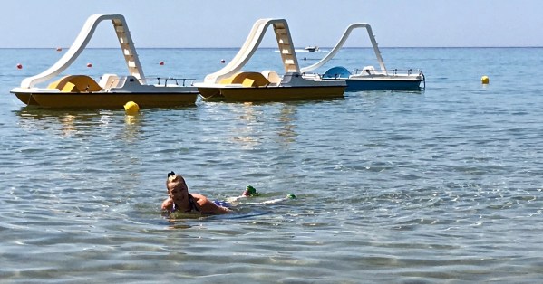 Sarah lay down in the sea with a pier in the background