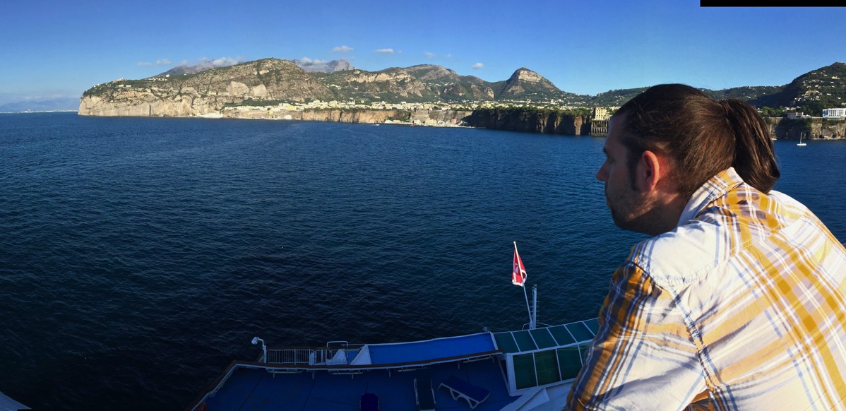 Sarah (on right) leaning on the ship rail and looking out over the sea to the land ahead