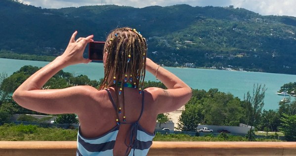 Sarah on the deck with the beautiful Jamaican background behind her