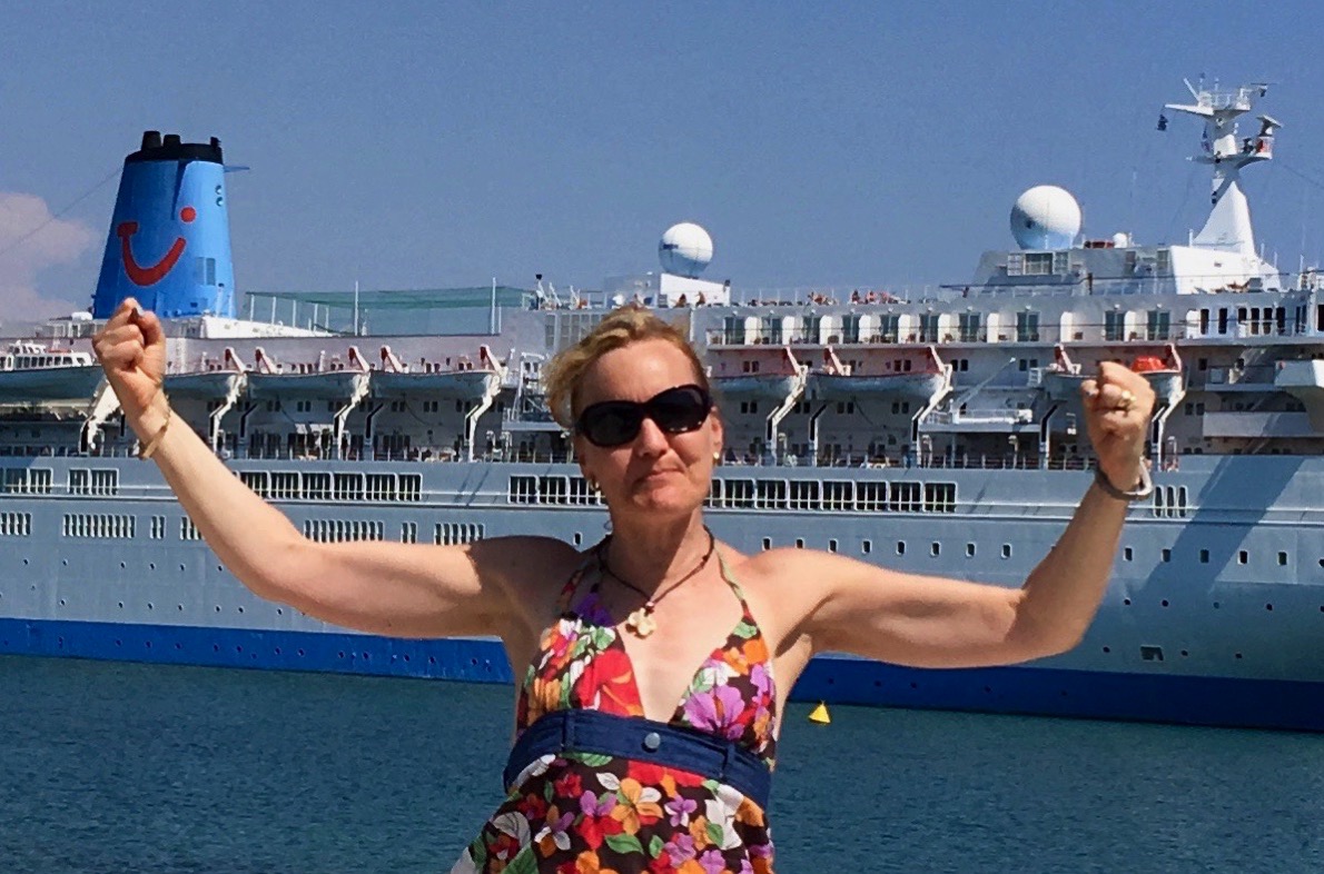 Sarah raising her arms in victory stood in front of the Thomson Spirit ship