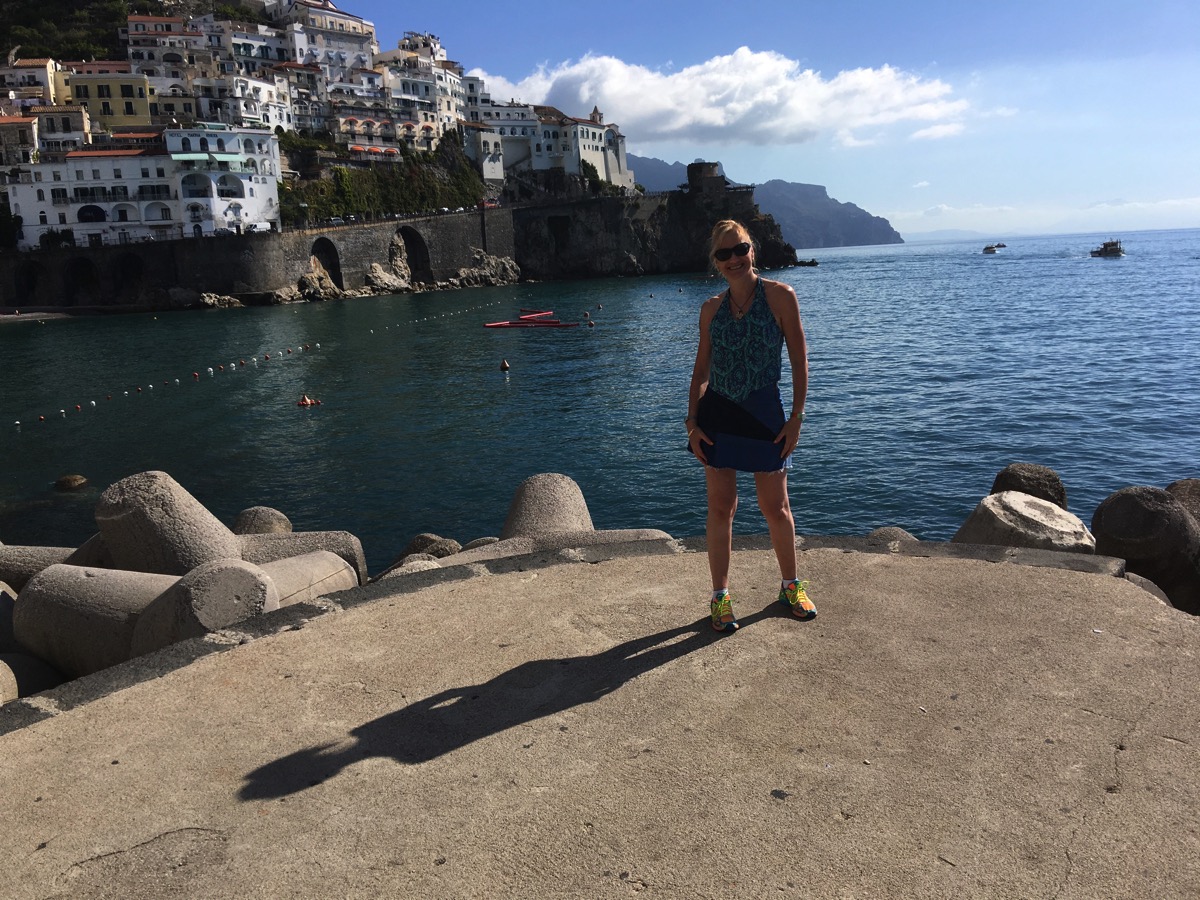 Sarah stood on the edge of the small dock with sea all around her and mountains in the background