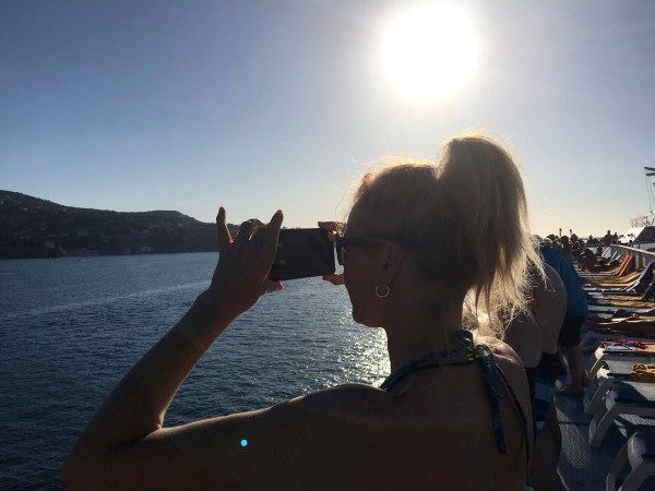 Sarah taking a photo of the sunset and landscape from the ship