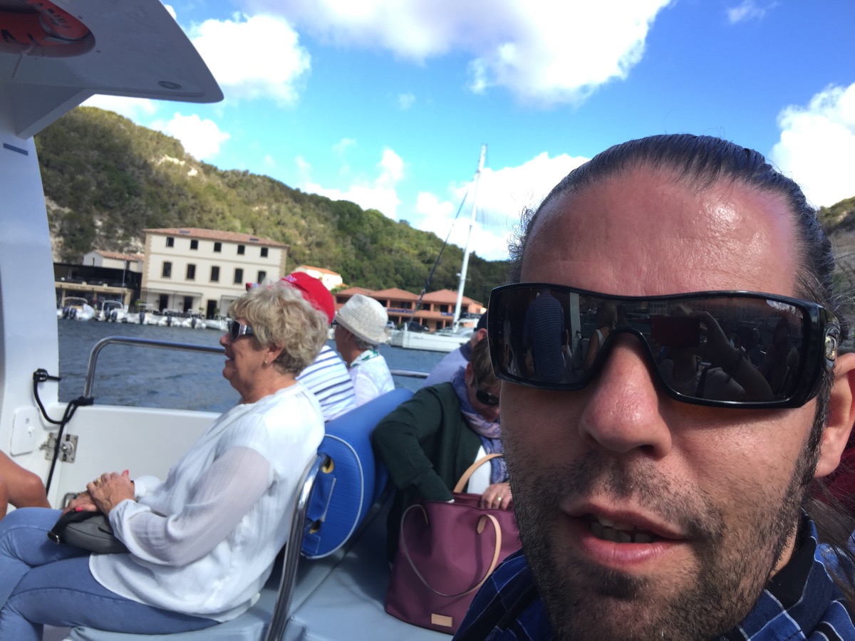 Selfie of me (bottom right) on the boat with the mountains behind 