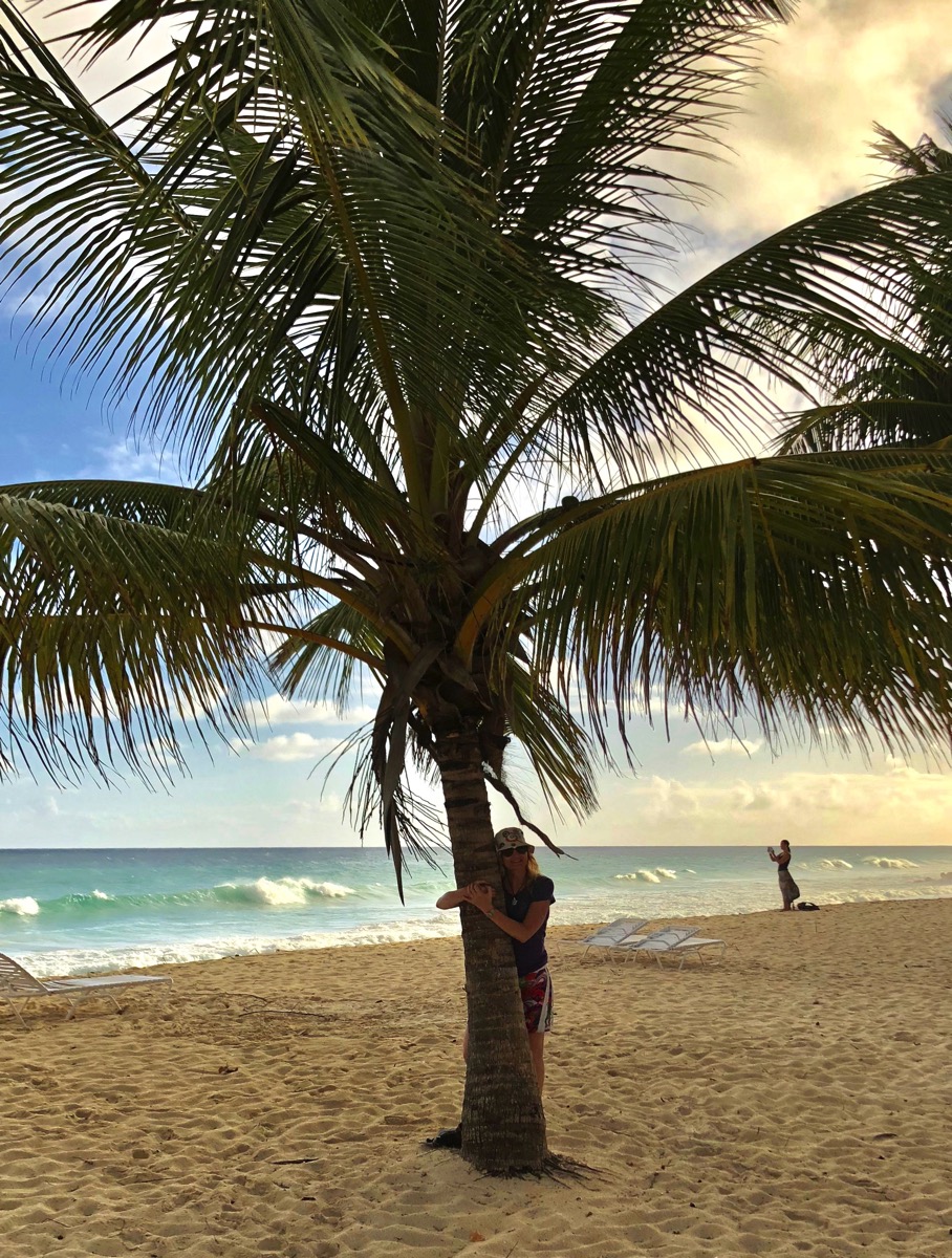 Sarah leaning on a palm tree