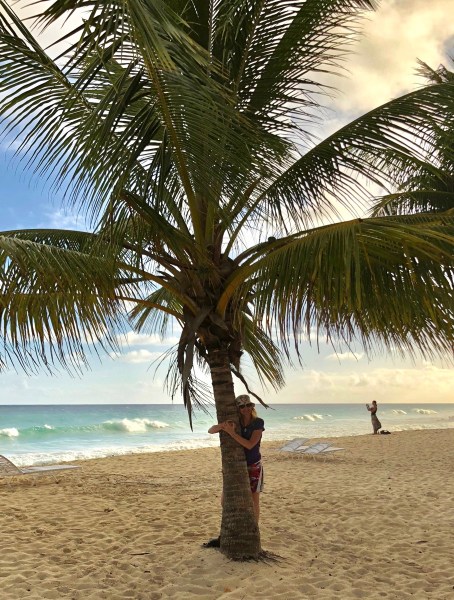 Sarah leaning on a palm tree