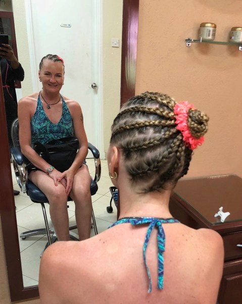 photo of Sarah and her new braides with her smiling in the mirror