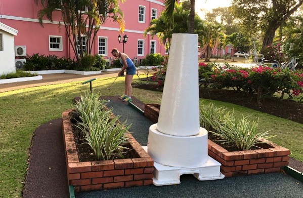 Sarah taking a shot on a lighhouse crazy golf course at Southern palms in Barbados